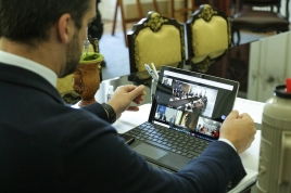 foto do governador no tablet em vídeo conferência com o presidente e outros governadores