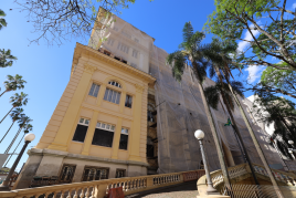 Imagem mostra a fachada do prédio-sede da Sefaz vista da Rua Siqueira Campos, no Centro de Porto Alegre. Do lado esquerda, é possível ver uma área do prédio com pintura diferente das demais, em tom mais amarelado.