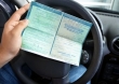 Documento de licenciamento do veículo, junto ao voltante do automóvel