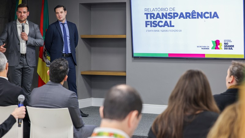 Dois servidores da Sefaz explicam o Relat&oacute;rio para jornalistas e servidores da Sefaz, que est&atilde;o sentados ouvindo